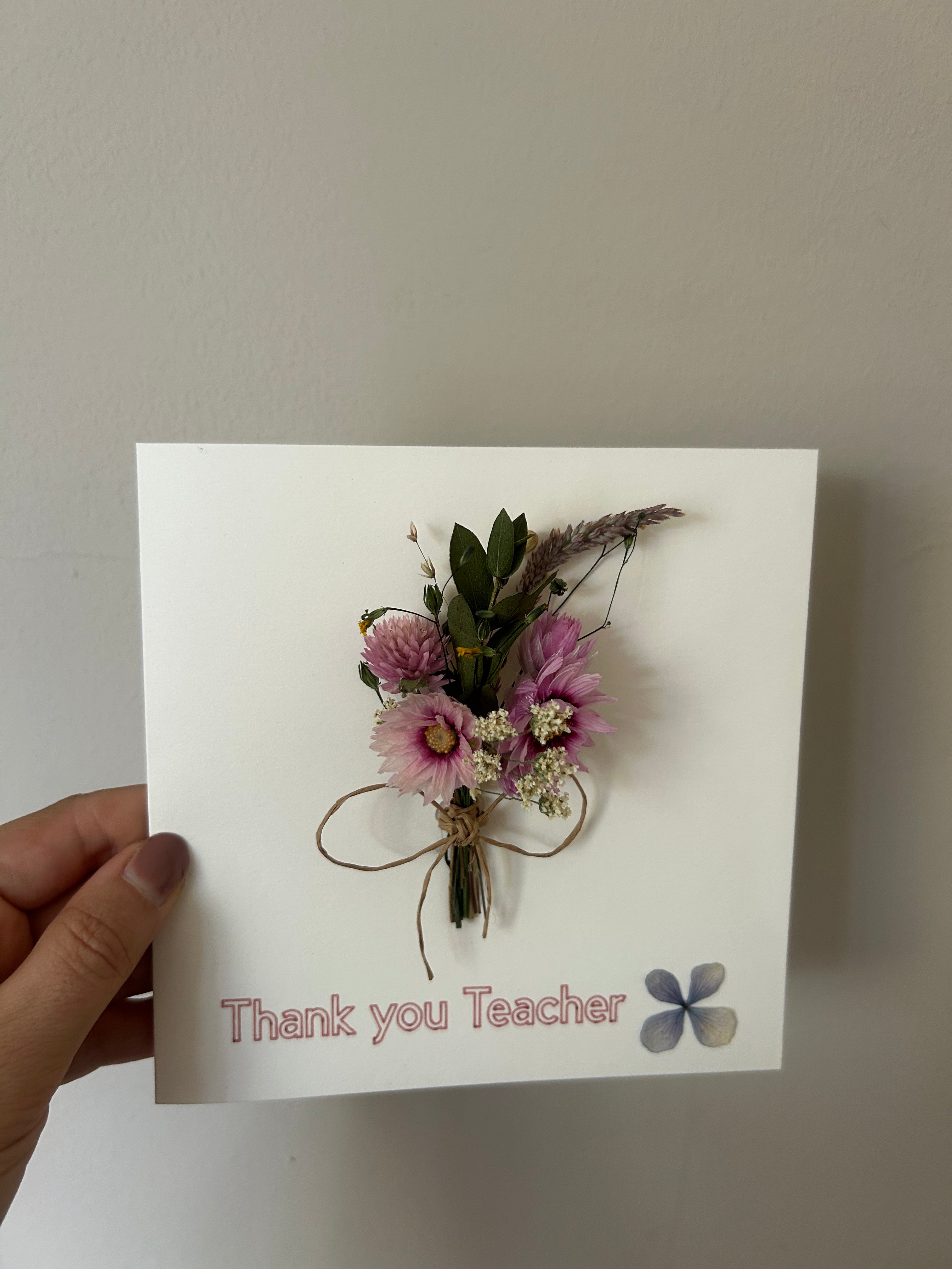 Card with a floral arrangement and 'Thank you Teacher' text on a plain background